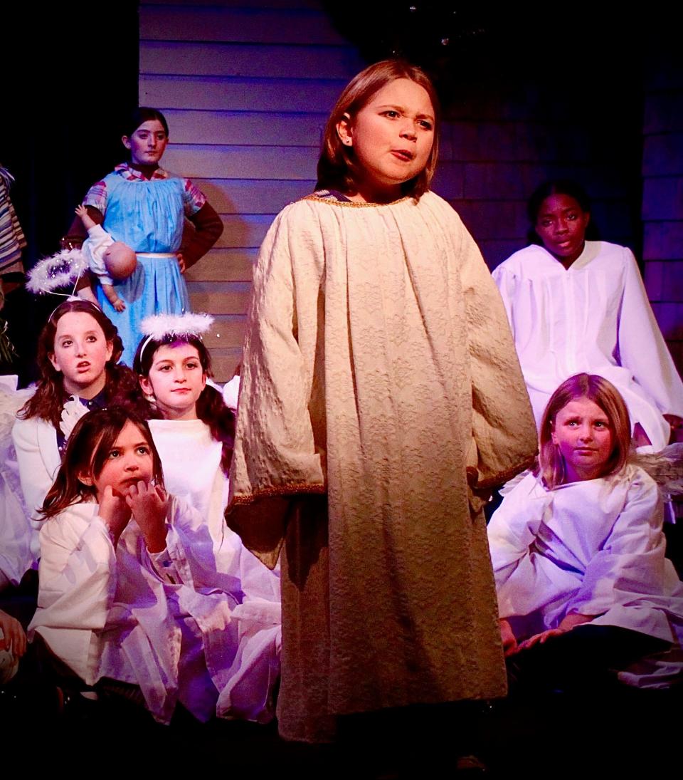 Gemma MacBride as Gladys Herdman, standing center, with members of the children's choir: Stella Seufert, far left in blue, Ashauri Martin, far right in white, seated front to back on the left: Aria Nickerson, Rebecca Reyes, Nora Angiolillo and, seated on the right, Elianna Taylor, in "The Best Christmas Pageant Ever" playing through Dec. 30 at Harwich Junior Theatre in West Harwich.