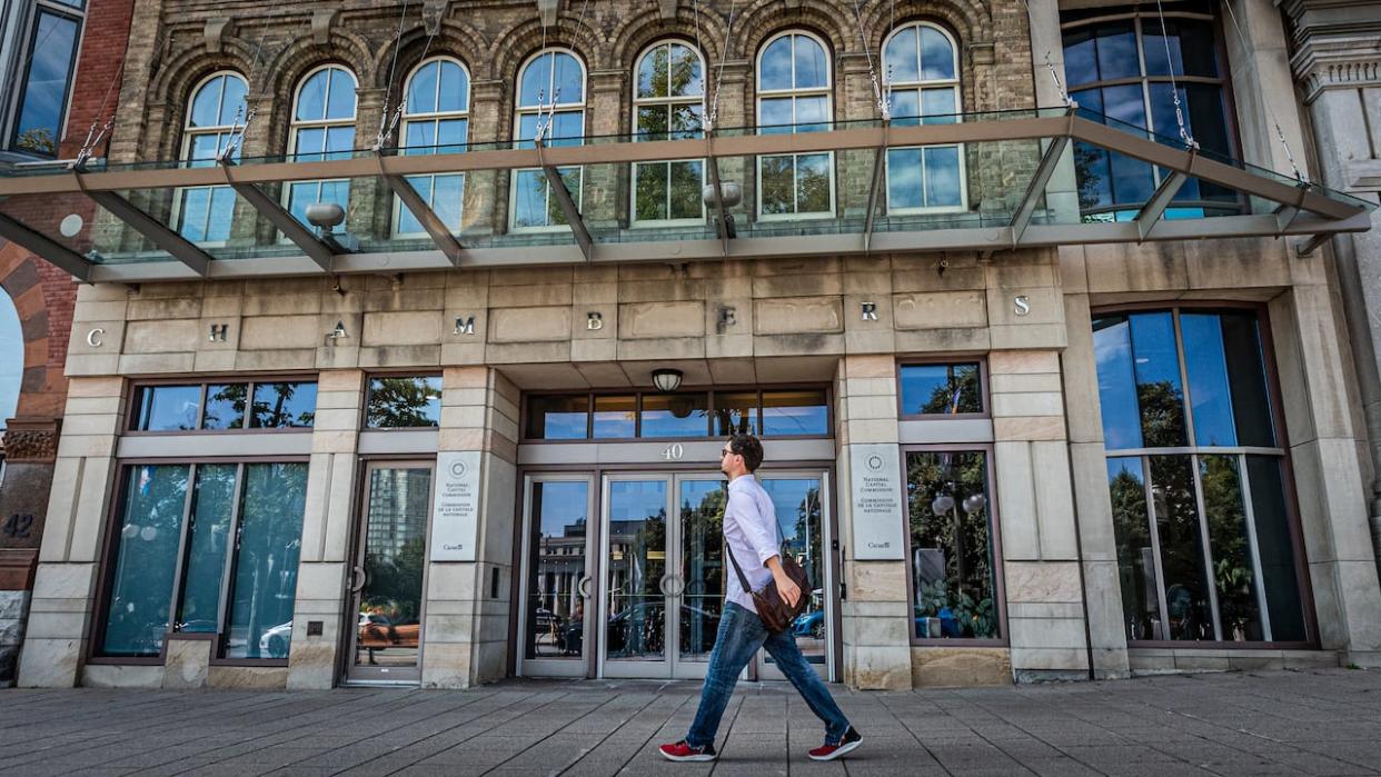 A man walks in downtown Ottawa in August 2023. The federal government has mandated a three-day hybrid schedule for its employees, to be implemented by Sept. 9 this year. (Brian Morris/CBC - image credit)