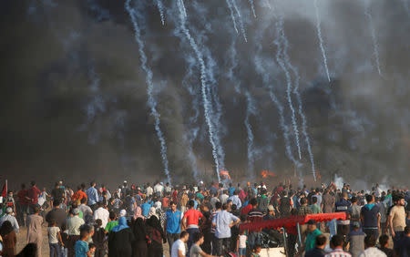 Tear gas canisters are fired by Israeli troops towards Palestinian demonstrators during a protest demanding the right to return to their homeland at the Israel-Gaza border, east of Gaza City August 3, 2018. REUTERS/Mohammed Salem