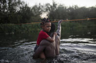 Haitian migrants wade across the Rio Grande from Del Rio, Texas, to return to Ciudad Acuña, Mexico, Sunday, Sept. 19, 2021, to avoid deportation to Haiti from the U.S. The U.S. is flying Haitians camped in a Texas border town back to their homeland and blocking others from crossing the border from Mexico in a massive show of force that signals the beginning of what could be one of America's swiftest, large-scale expulsions of migrants or refugees in decades. (AP Photo/Felix Marquez)