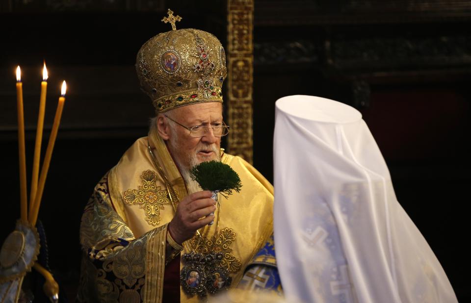 Ecumenical Patriarch Bartholomew I, left, blesses Metropolitan Epiphanius, the head of the independent Ukrainian Orthodox Church, back to a camera, at the Patriarchal Church of St. George in Istanbul, Sunday, Jan. 6, 2019. An independent Ukrainian Orthodox church has been created at a signing ceremony in Turkey, formalizing a split with the Russian church it had been tied to since 1686. (AP Photo/Lefteris Pitarakis)