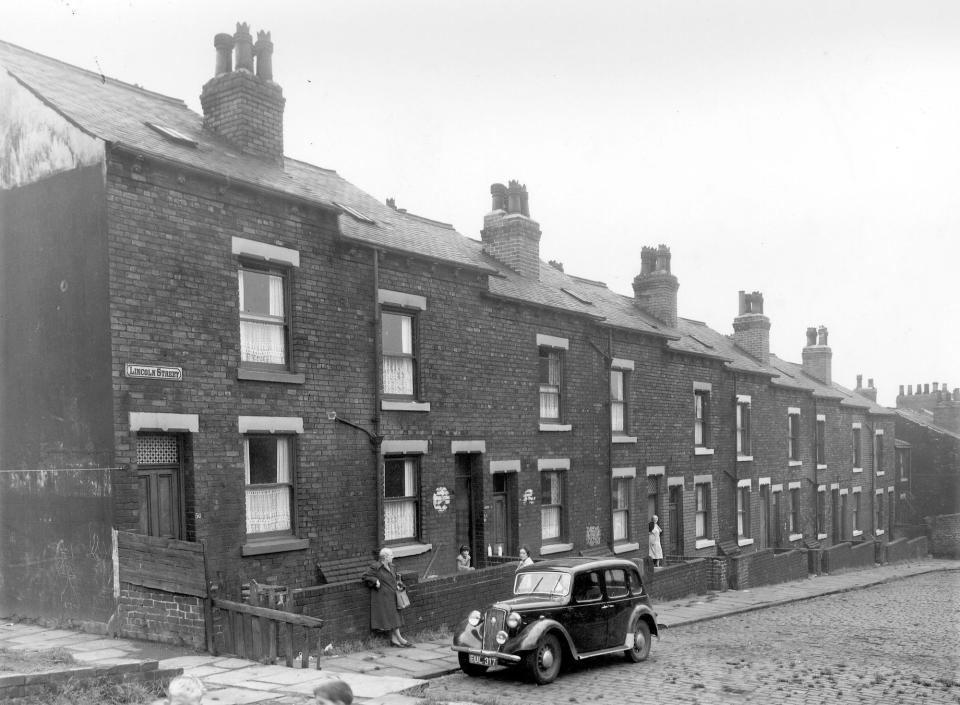 A long view of Lincoln Street in August 1958. Several people are visible in the photograph and a car is parked on the street.