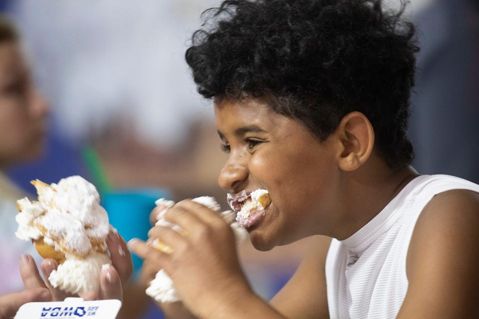 Micah Wolf of West Bend enjoys eating his first-ever cream puff at the Wisconsin State Fair in 2021.
