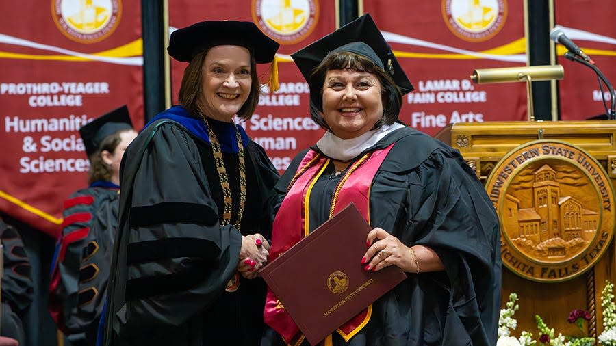 Dr. Stacia Haynie, Midwestern State University president, (left) presents DaNette Stalnaker with her diploma at the commencement ceremony Friday, Dec. 15.