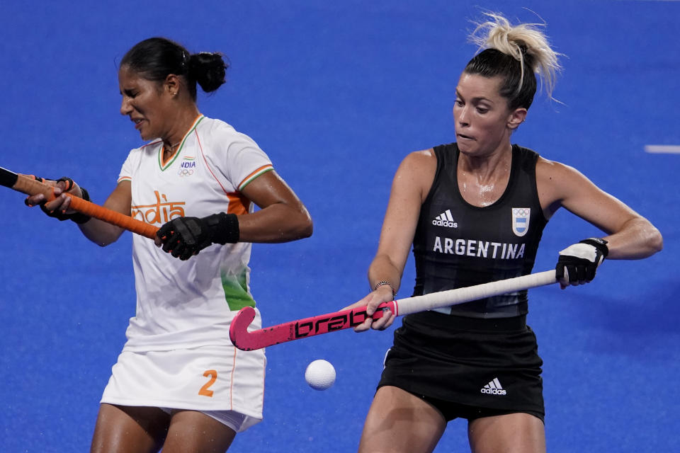 La argentina Agustina Albertarrio, a la derecha, y Gurjit Kaur, de la India, a la izquierda, reaccionan a una pelota suelta durante un partido por las semifinales del hockey sobre césped femenino en los Juegos Olímpicos de Verano 2020, en Tokio, Japón, el miércoles 4 de agosto del 2021.(Foto AP/John Locher)