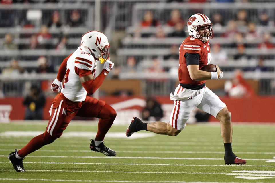 Wisconsin's Tanner Mordecai runs against Nebraska's Marques Buford Jr. during the first half of an NCAA college football game Saturday, Nov. 18, 2023 in Madison, Wis. (AP Photo/Aaron Gash)