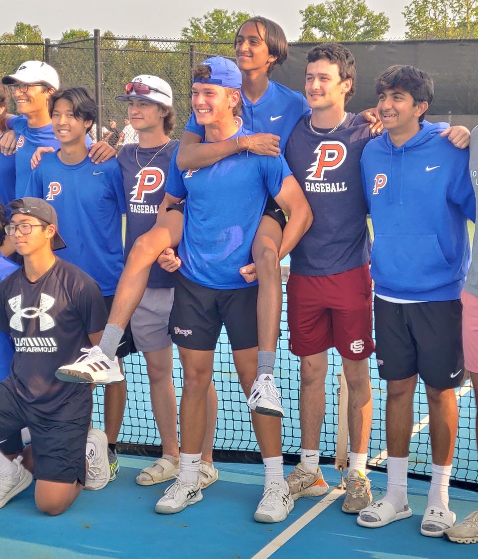 Flanked by teammates and fans, Olentangy Orange tennis players Austin Jackson (center) and Shailen Patel (center right, being held by Jackson) celebrate a 3-0 win at New Albany in the Ohio Tennis Coaches Association Division I district final Thursday.