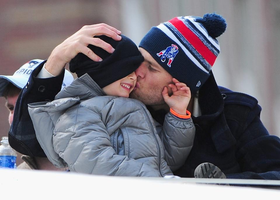 Tom Brady of the New England Patriots kisses his son Benjamin during a Super Bowl victory parade on February 4, 2015 in Boston, Massachusetts