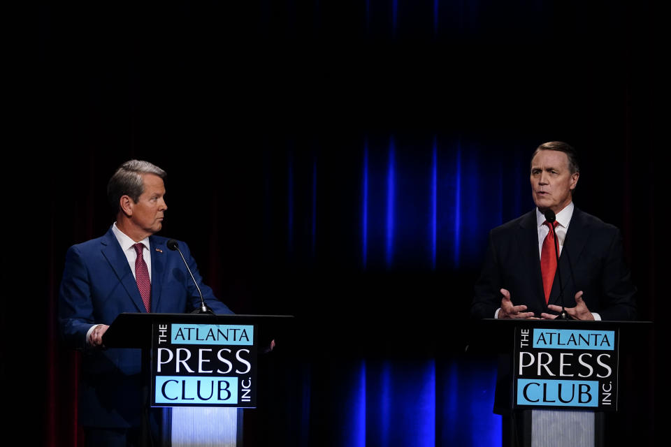 Former Sen. David Perdue, right, speaks during a gubernatorial Republican primary debate toward Georgia Gov. Brian Kemp, left, Sunday, May 1, 2022, in Atlanta. (AP Photo/Brynn Anderson, Pool)