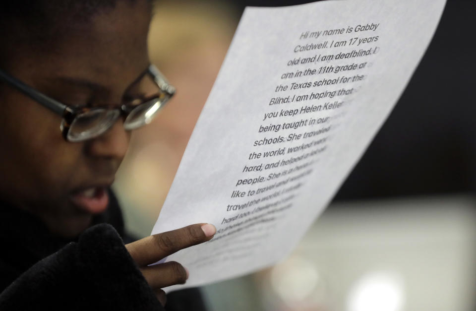 Gabrielle Caldwell, who is partially deaf and blind, looks over her notes where she testified before the Texas School Board during public testimony as they prepares to vote on history curriculum, Tuesday, Nov. 13, 2018, in Austin, Texas. The Republican-controlled board is hearing from activists and academics who are defending or decrying proposed edits meant to streamline academic standards for history. (AP Photo/Eric Gay)