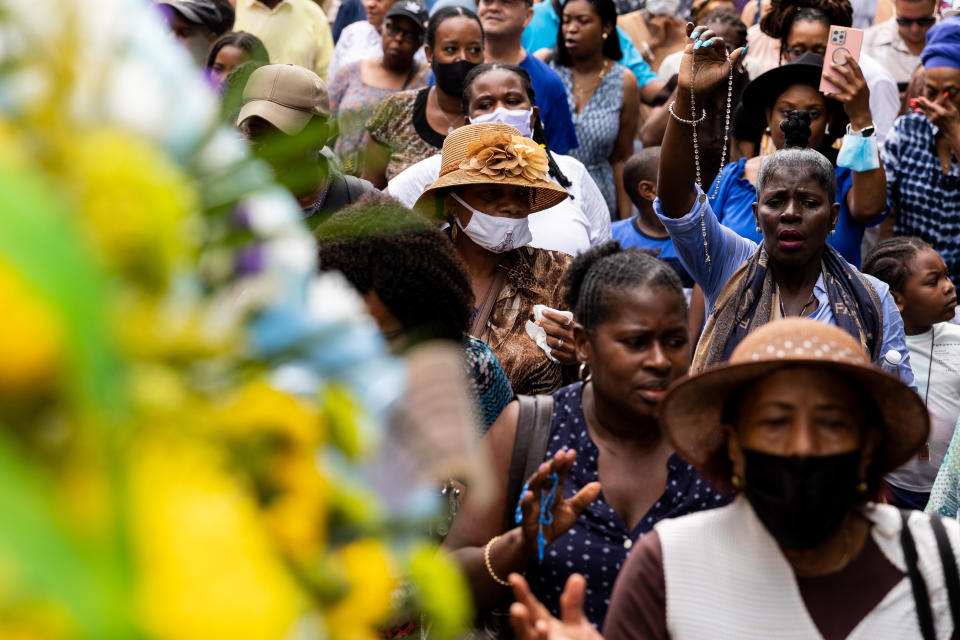 A woman holds up a rosary as she joins parishioners in a procession behind a float carrying Our Lady of Mount Carmel, Saturday, July 16, 2022, in the Brooklyn borough of New York. (AP Photo/Julia Nikhinson)