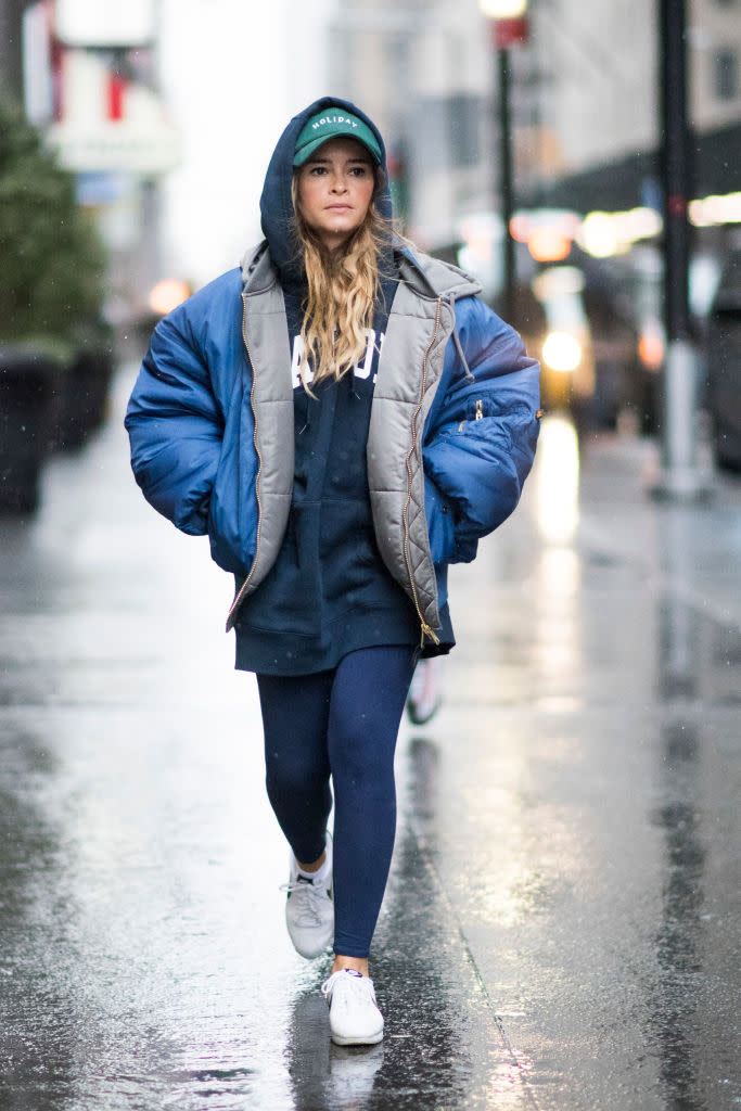 <p>Miroslava Duma is one of the most photographed street-style stars, and proves that you don’t need to dress to the nines to look chic. If you prefer to be more casual, this look is all about the layers: puffer coat, hoodie, leggings, sneakers, and baseball cap. (Photo: Getty Images) </p>