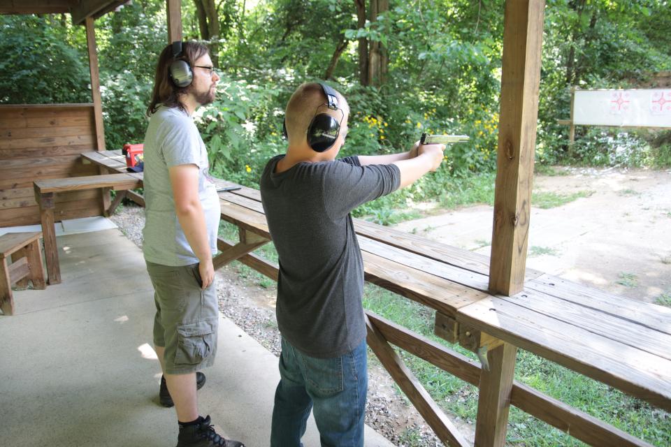 Instructor Aaron Findley, left, watches as Clayton Thoroughman, 12, of Garden City shoots a pistol Saturday, Aug. 6, 2022, at the Lenawee County Conservation League.