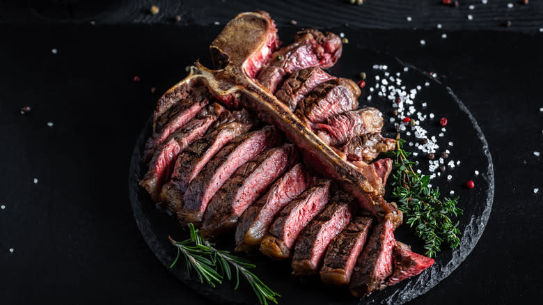 Sliced porterhouse steak on stone