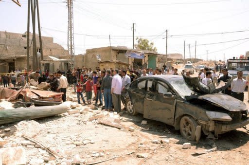 Handout photo from the Syrian Arab News Agency shows residents gathered around the reckage caused by a car bomb in the Syrian city of Aleppo on May 5. Syria's authorities and the opposition traded accusations Sunday over who was behind blasts that rocked Damascus and Aleppo, on the eve of parliamentary polls designed to boost the regime's legitimacy