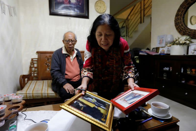 Nina Widyawati, 65-year-old mother of Ratih Purwarini, a doctor who passed away due to the coronavirus disease (COVID-19), shows photographs of her daughter, as her husband Bambang Purnomo Sidik sits at their house in Jakarta