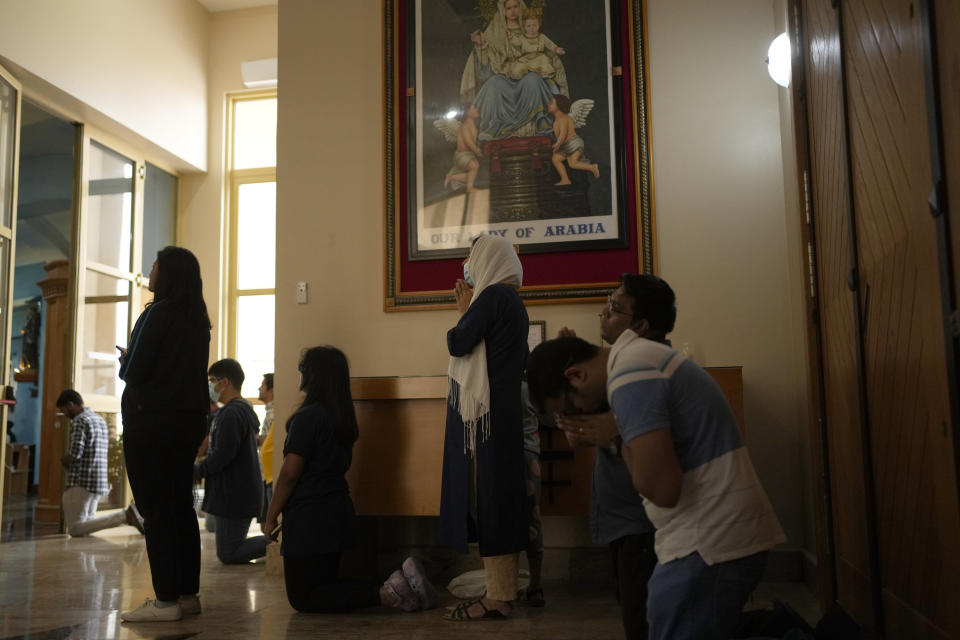 People pray during a liturgy at the Catholic Church, Our Lady of the Rosary, at the Religious complex, in Doha, Qatar, Friday, Dec. 9, 2022. (AP Photo/Thanassis Stavrakis)