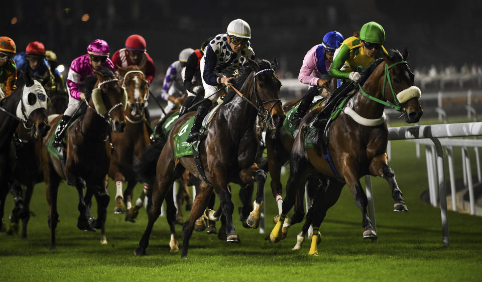 Horses gallop into the first turn in Saudi International Handicap over 2100m during the International Jockeys Challenge at the King Abdulaziz racetrack in Riyadh, Saudi Arabia, Friday, February 24, 2023. (AP Photo/Martin Dokoupil)