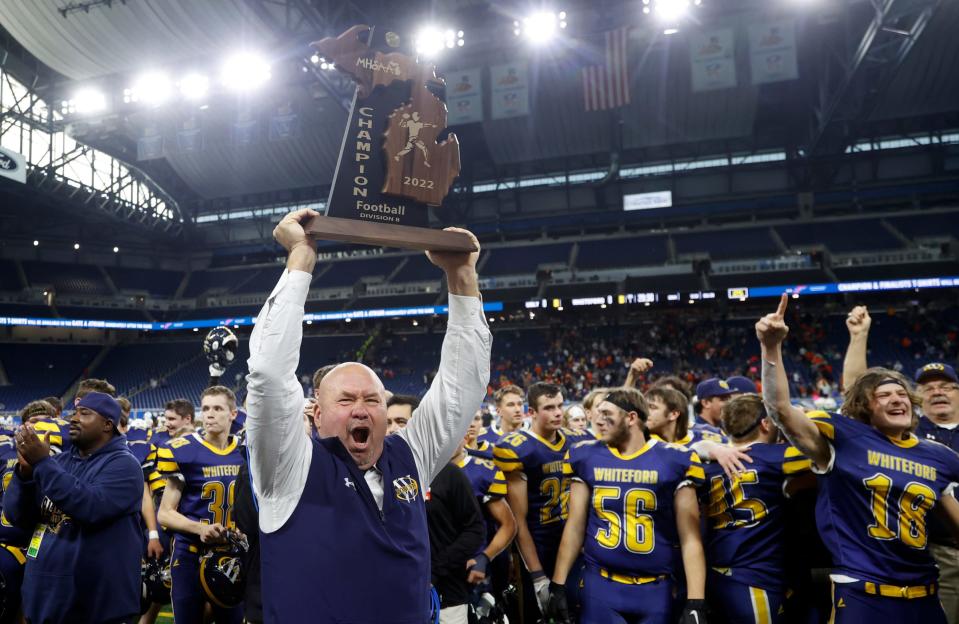 Ottawa Lake Whiteford coach Todd Thieken celebrates with the state championship trophy after Whiteford's 26-20 win over Ubly in the Division 8 football final at Ford Field on Friday, Nov 25, 2022.