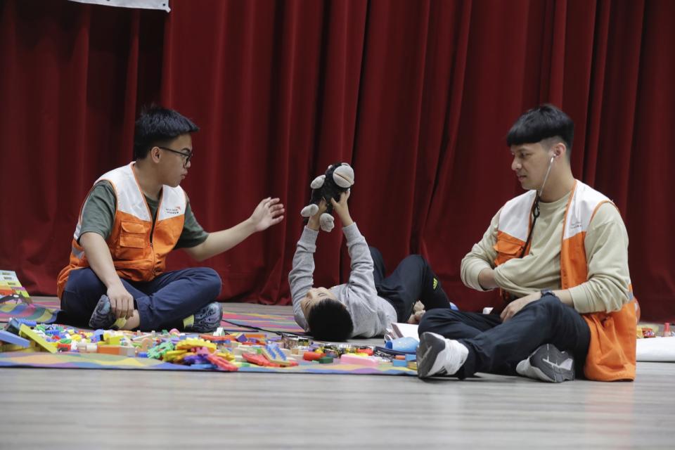 2名志工在災民收容中心陪伴受災的兒童玩耍。美聯社