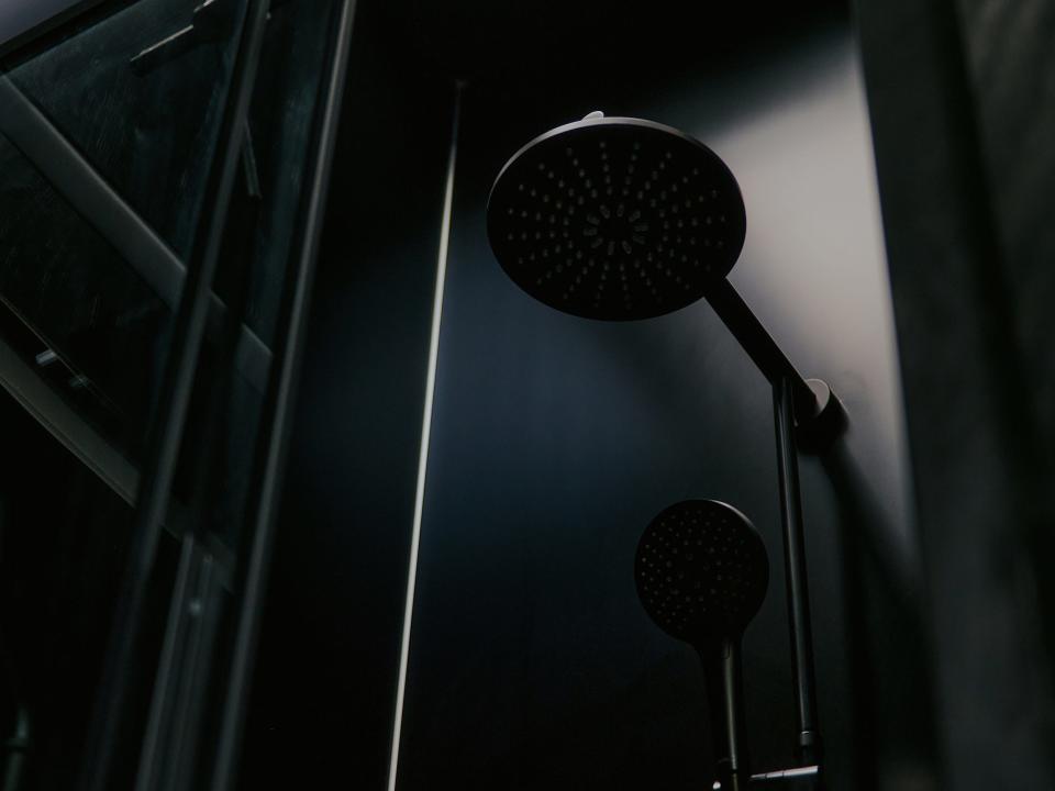 A black minimalist shower inside a Raus cabin.