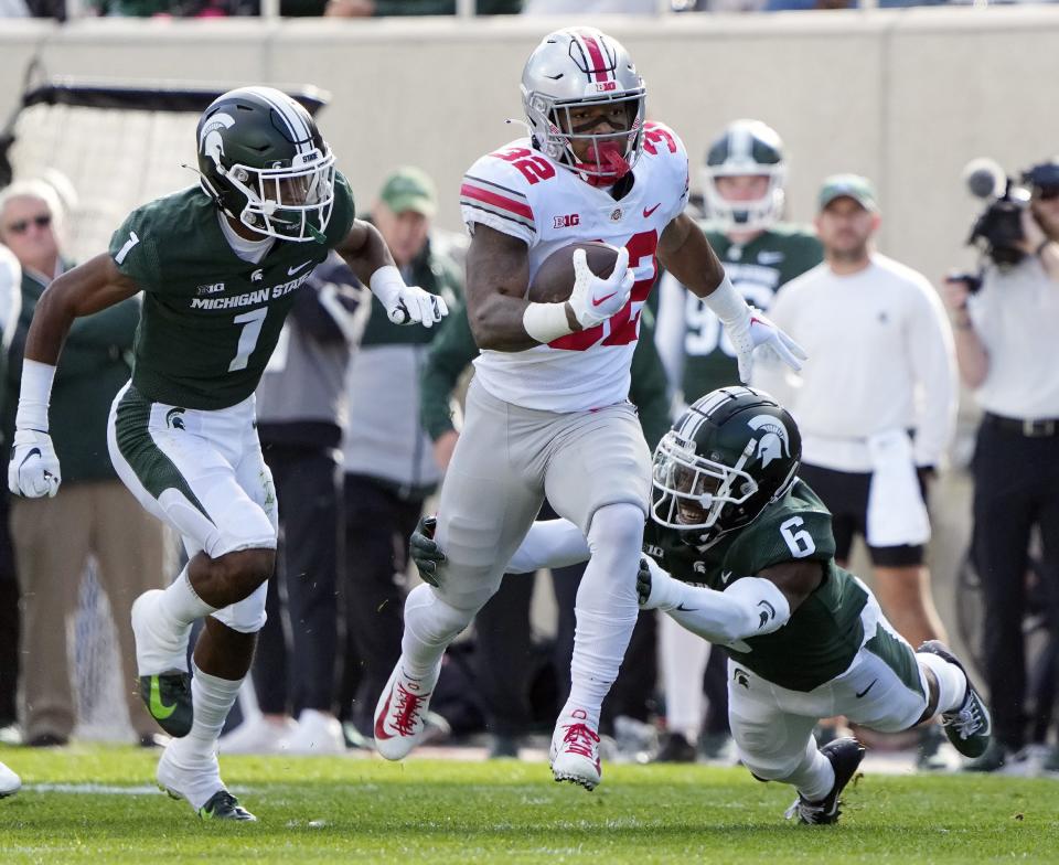 Oct 8, 2022; East Lansing, Michigan, USA; Ohio State Buckeyes running back TreVeyon Henderson (32) carries the ball past Michigan State Spartans cornerback Ameer Speed (6) in the first quarter of the NCAA Division I football game between the Ohio State Buckeyes and Michigan State Spartans at Spartan Stadium. 