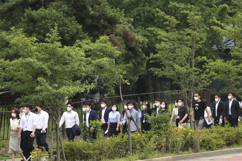 People wearing face masks to help protect against the spread of the new coronavirus cross a road in Seoul, Monday, June 29, 2020. (AP Photo/Ahn Young-joon)