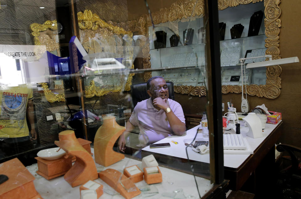 A Sri Lankan Muslim jewelry shop owner Jifferey sits in his vandalized showroom following overnight clashes in Poruthota, a village in Negombo, about 35 kilometers North of Colombo, Sri Lanka, Monday, May 6, 2019. Two people have been arrested and an overnight curfew lifted Monday after mobs attacked Muslim-owned shops and some vehicles in a Sri Lankan town where a suicide bombing targeted a Catholic church last month. Residents in the seaside town of Negombo say the mostly-Catholic attackers stoned and vandalized shops. It is unclear how the dispute began but most residents say a private dispute took a religious turn. (AP Photo/Eranga Jayawardena)