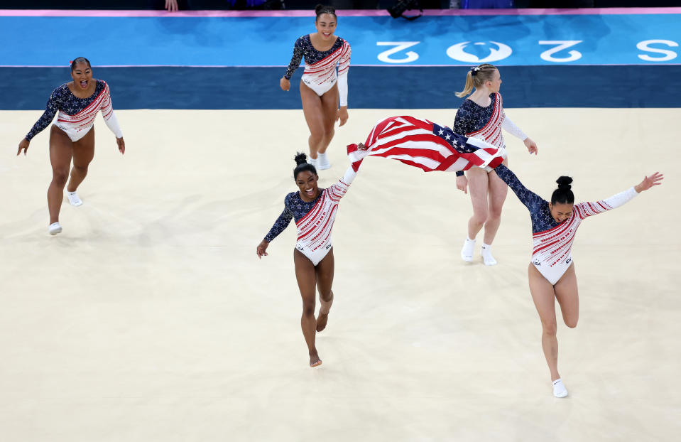 PARIS, FRANCE - JULY 30: (L-R) Jordan Chiles, Hezly Rivera,  Simone Biles, Jade Carey and Sunisa Lee of Team United States celebrate winning the gold medals during the Artistic Gymnastics Women's Team Final on day four of the Olympic Games Paris 2024 at Bercy Arena on July 30, 2024 in Paris, France. (Photo by Ezra Shaw/Getty Images)