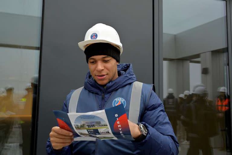 Mbappé observa un folleto con el detalle de las instalaciones.