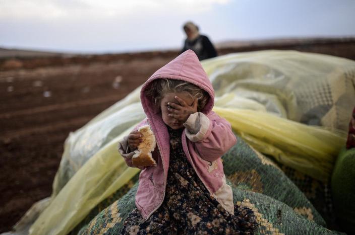 A Syrian Kurdish woman wait with her daughter near the Syria border at the southeastern town of Suruc after crossing the border between Syria and Turkey (AFP Photo/Bulent Kilic)