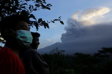Villagers watch as Mount Agung volcano spews ash during an eruption from the Volcanic Observatory in Rendang Village, Karangasem, Bali, Indonesia November 26, 2017. REUTERS/Johannes P. Christo
