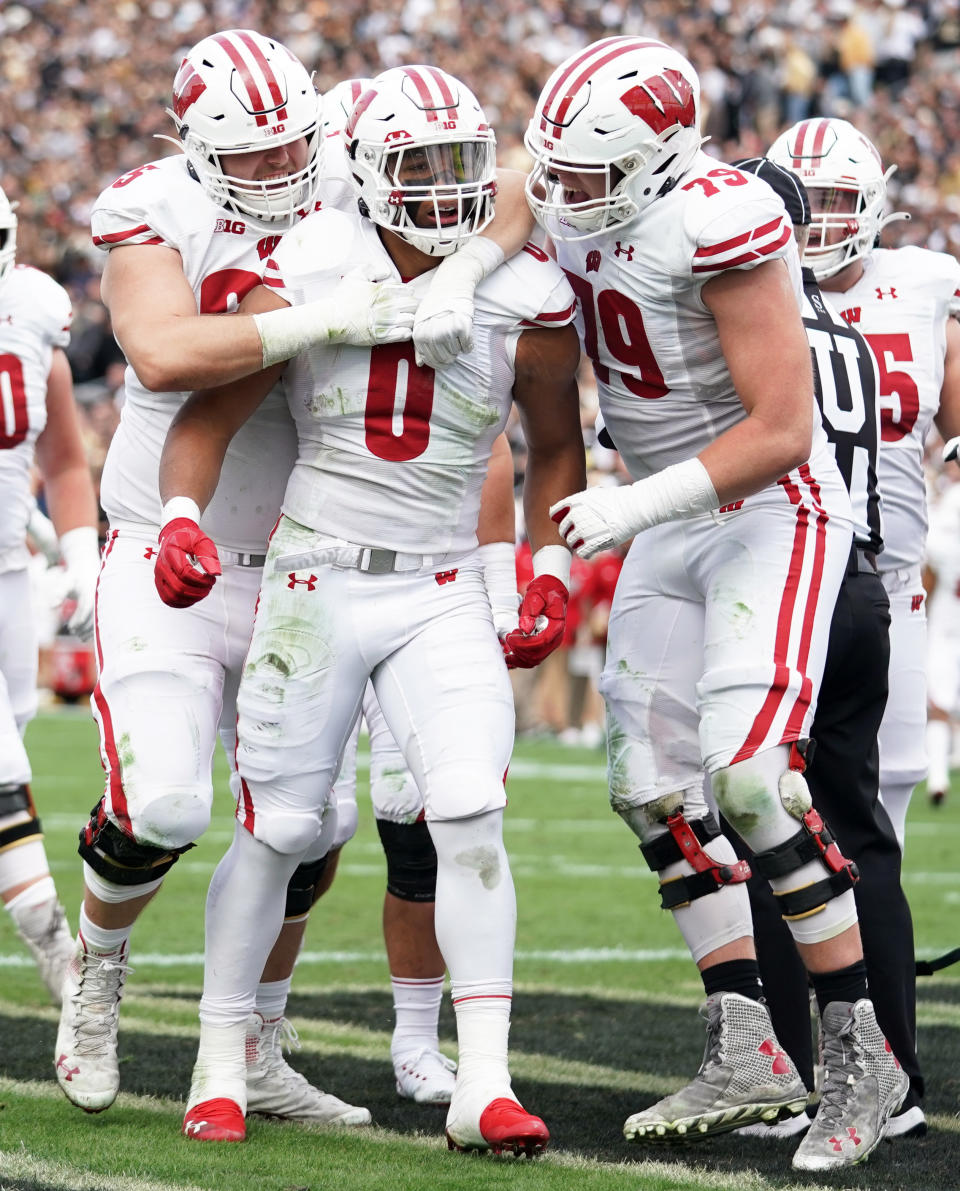 Oct. 23, 2021; West Lafayette, Indiana; Wisconsin Badgers running back Braelon Allen (0) is congratulated by Wisconsin Badgers offensive lineman Tyler Beach (65) and Wisconsin Badgers offensive lineman Jack Nelson (79) after scoring a touchdown during the game at Ross-Ade Stadium. Robert Goddin-USA TODAY Sports