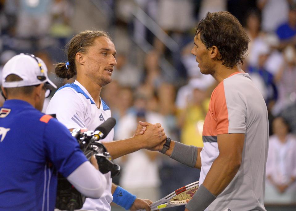 Alexandr Dolgopolov, left, of Ukraine, shakes hands with Rafael Nadal, of Spain, after defeating him in their match at the BNP Paribas Open tennis tournament, Monday, March 10, 2014, in Indian Wells, Calif. Dolgopolov won 6-3, 3-6, 7-6 (5). (AP Photo/Mark J. Terrill)