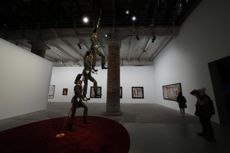 A visitor looks at the "Pret A Patria" installation by artist Barbara Sanchez Kane at the 60th Biennale of Arts exhibition in Venice, Italy, Tuesday, April 16, 2024. The Venice Biennale contemporary art exhibition opens Saturday for its six-month run through Nov. 26. (AP Photo/Luca Bruno)