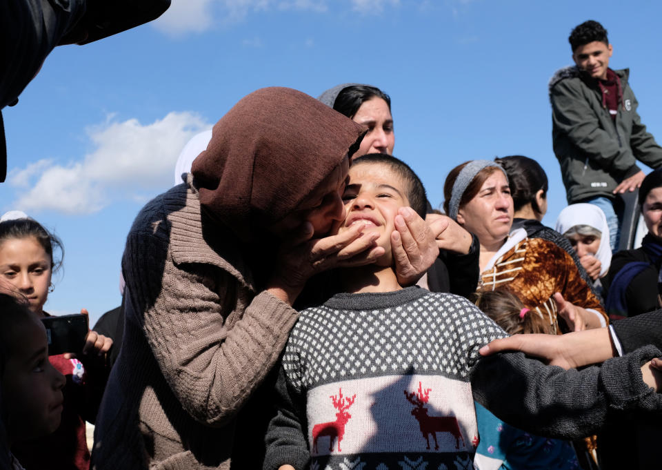 Dilbar Ali Ravu, 10, is kissed by his aunt Dalal Ravu after Yazidi children were reunited with their families in Iraq after five years of captivity with the Islamic State group, Saturday, March 2, 2019. Elated families met their loved ones at a truck stop on the road between Sinjar and Dohuk, tossing candy like confetti and ululating in joy. The group of 3 Yazidi women and 18 children had crossed into Iraq from Syria on Thursday. They are among thousands of civilians who emerged in the last few days from the last speck of territory held by the Islamic State group in the village of Baghouz, in eastern Syria. (AP Photo/Philip Issa)