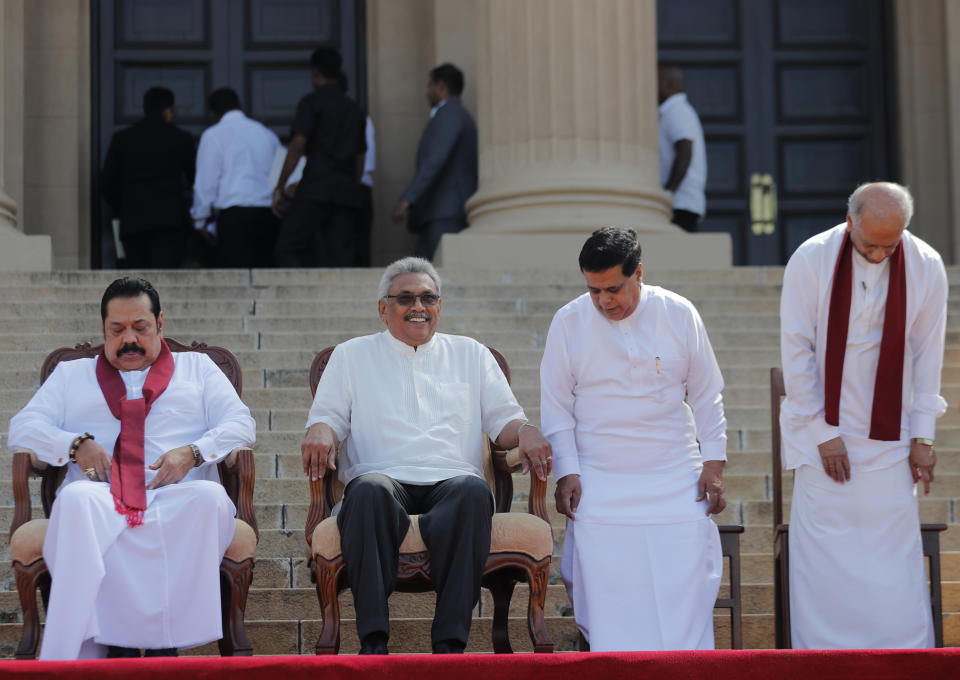 Sri Lankan president Gotabaya Rajapaksa, second left, sits for photographs with his new cabinet members in Colombo, Sri Lanka, Friday, Nov. 22, 2019. Rajapaksa, who was elected last week, said he would call a parliamentary election as early as allowed. The parliamentary term ends next August, and the constitution allows the president to dissolve Parliament in March and go for an election. (AP Photo/Eranga Jayawardena)