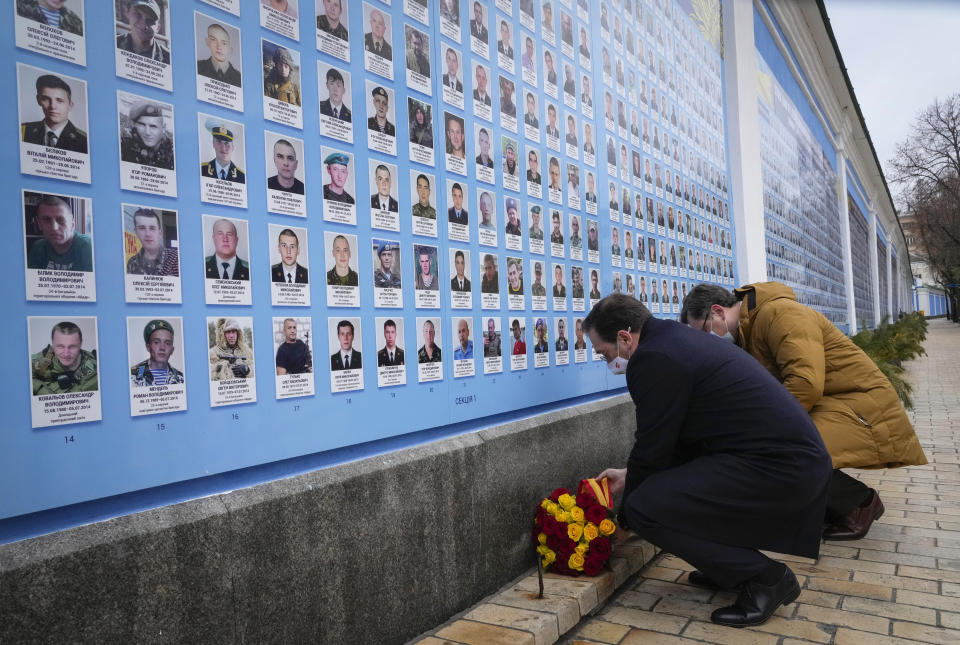 Ukrainian Foreign Minister Dmytro Kuleba, right, and Spanish Foreign Minister Jose Manuel Albares lay flowers at the Memorial Wall of Fallen Defenders of Ukraine in Russian-Ukrainian War in Kyiv, Ukraine, Wednesday, Feb. 9, 2022. (AP Photo/Efrem Lukatsky)