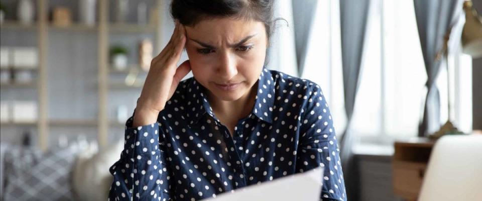 Woman sit at desk hold document