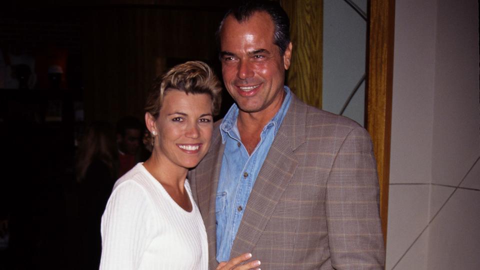 vanna white, wearing a white sweater and jeans, stands with george san pietro, who wears a gray patterned suit jacket and blue shirt