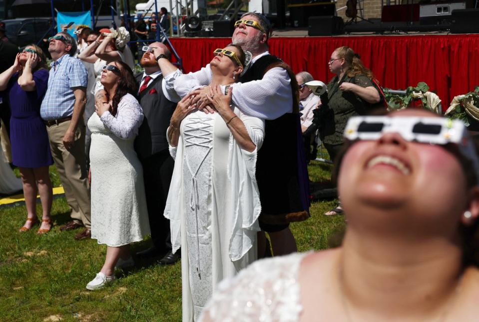 Couples view the solar eclipse during a mass wedding at the Total Eclipse of the Heart festival in Russellville, Ark.<span class="copyright">Mario Tama—Getty Images</span>