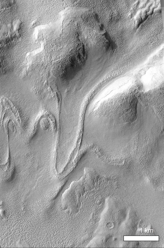 Orbital photos from NASA Mars Reconnaissance Orbiter shows lobate-shaped glacier flowing down the north inner wall of crater Greg, on the planet Mars. The wall slopes downhill to the south (bottom) part of the frame. Note how flow lines drape a