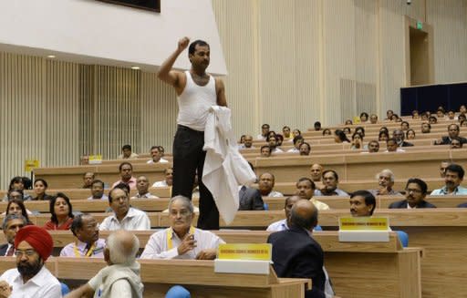 A demonstrator shouts slogans in protest before a speech by Indian Prime Minister Manmohan Singh in New Delhi. Security men muscled away the protester who heckled Singh,