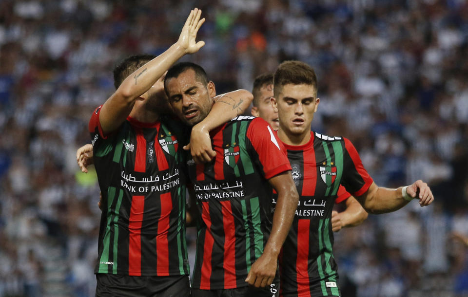 César Cortez (centro) festeja con sus compañeros de Palestino de Chile, luego de anotar el primer tanto del equipo ante Talleres de Argentina, en un duelo de la Copa Libertadores, realizado el miércoles 20 de febrero de 2019 (AP Foto/Víctor Quiroga)