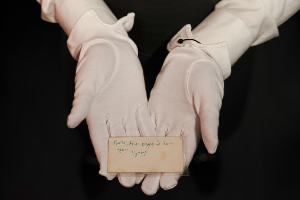 A member of staff holds a handwritten note by George Harrison, as part of The Pattie Boyd Collection at Christie's, in London, Thursday, March 14, 2024. The note is estimated to sell £2,000-3,000. (AP Photo/Alberto Pezzali)