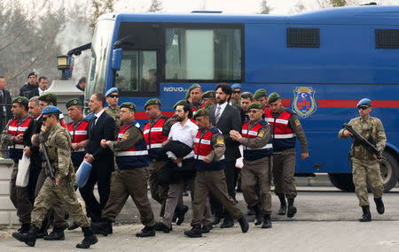 Turkish soldiers accused of attempting to assassinate President Tayyip Erdogan on the night of the failed last year's July 15 coup, are escorted by gendarmes as they arrive for the first hearing of the trial in Mugla, Turkey, February 20, 2017. REUTERS/Kenan Gurbuz