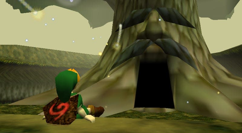 A young link sits in front of the Great Deku Tree as seen in Ocarina of Time on N64. 