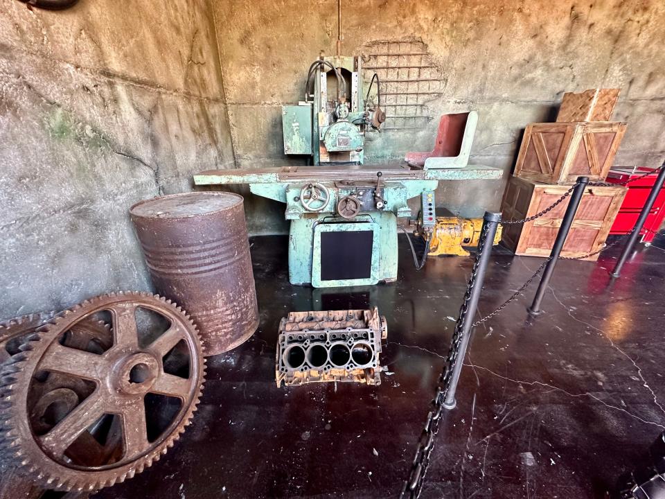 barrels, gears, and other rusty-looking supplies in the corner of a room