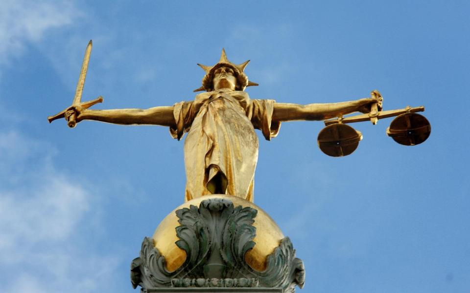 Lady Justice, holding scales and a sword, on top of the Central Criminal Court - PA