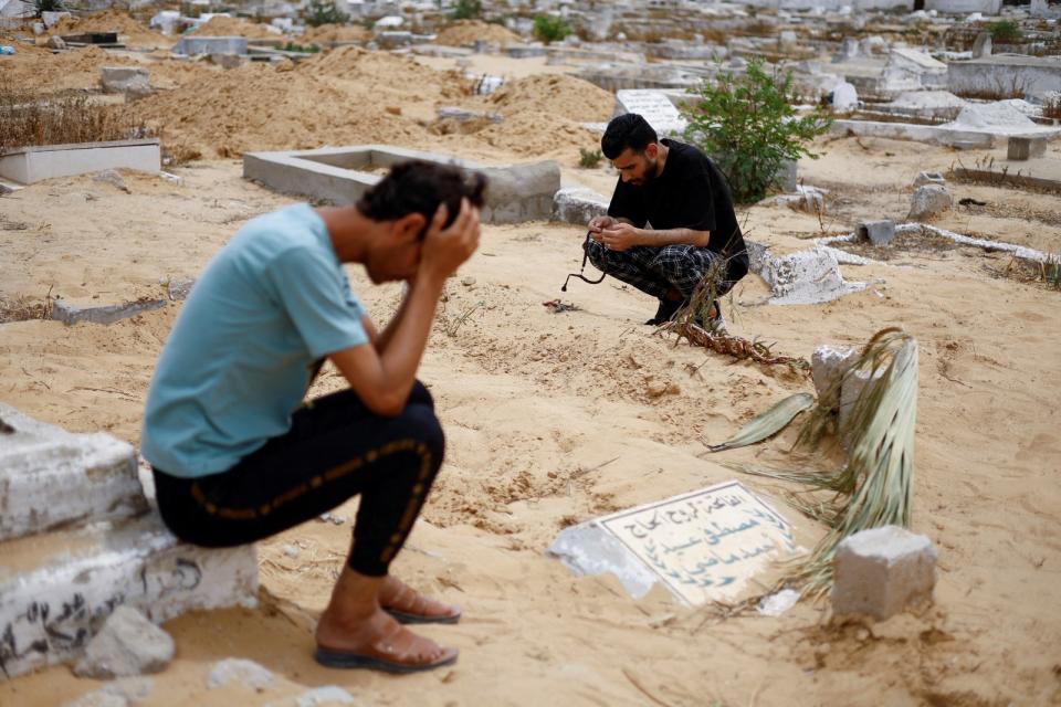 2024年4月26日，加薩走廊南部拉法一處墓地。圖中的黑衣男子正在哀悼一名僅30週大、緊急剖腹救出後僅存活5天的女嬰，女嬰的父母皆死於空襲。路透社